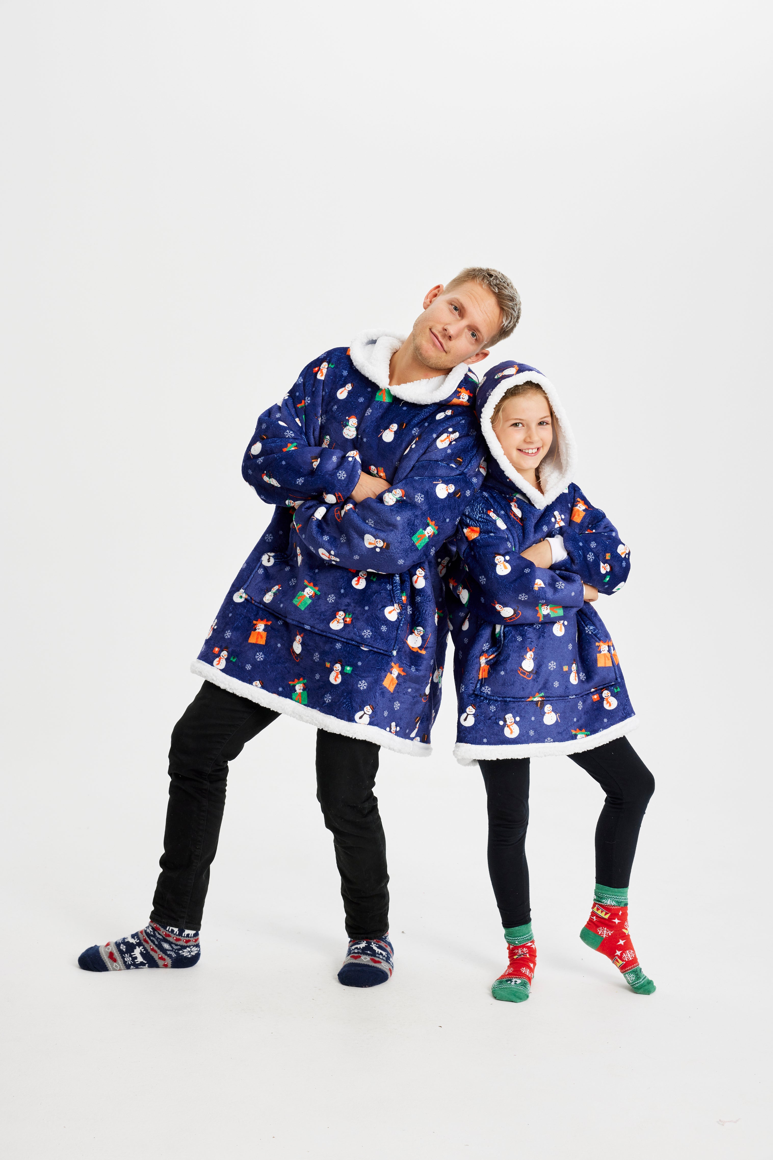 Een kind en een man die een blauwe kerst hoodie met sneeuwpoppen dragen.
